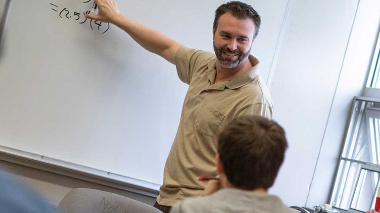 Professor at white board in math class