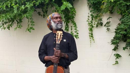 Corey Harris, a musician, poses with his musical instrument. 